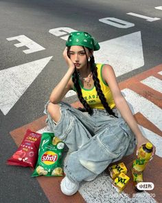 Woman in a green bandana and ripped jeans sitting on a street