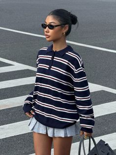 Woman in a striped polo shirt and pleated skirt on a street