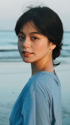Woman with short dark hair in a blue shirt at the beach
