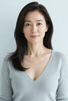 Woman with long black hair wearing a grey v-neck sweater