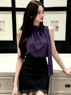Woman with long dark hair wearing a purple top and black lace-trim skirt indoors
