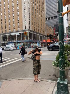 Woman in a crop top and camouflage pants on a city street