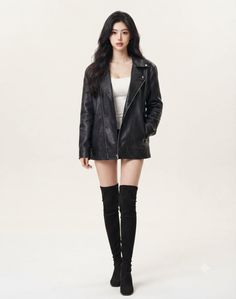 Woman in a black leather jacket, white top, and thigh high boots