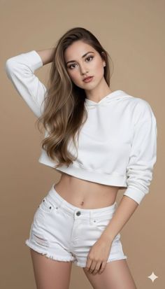 Woman in a white crop top and shorts posing in a studio