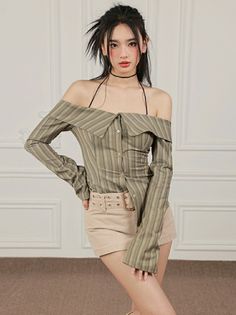 Woman in an off-shoulder striped shirt and shorts posing indoors