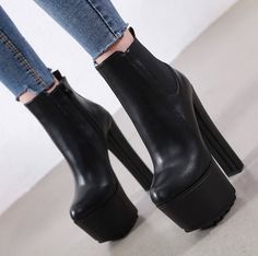 Person wearing black platform ankle boots and cropped denim jeans