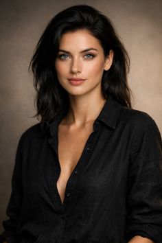 Woman with black hair and blue eyes wearing an open black shirt