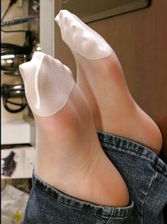 Feet wearing white socks and denim jeans, close up shot