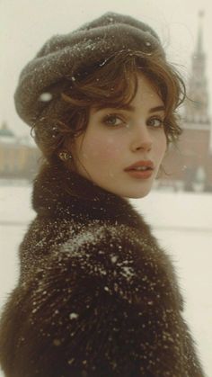 Woman in a winter hat and fur coat with snow on her shoulders