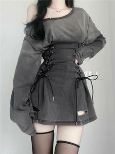 Person in a dark off-shoulder corset dress and thigh-high stockings