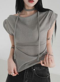 Woman with long black hair wearing a ribbed top and choker