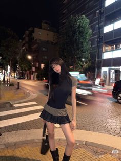 Woman with long hair in a mini skirt on a city street at night