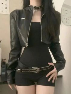 Person in a black leather jacket, black top, and shorts with a choker