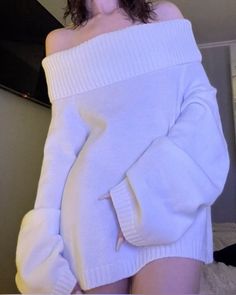 Person in a white off-shoulder sweater with exposed skin indoors