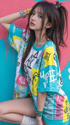 Woman with long hair wearing a colorful t-shirt against a graffiti wall