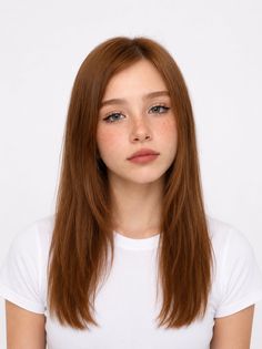 Young woman with long red hair and freckles wearing a white t-shirt