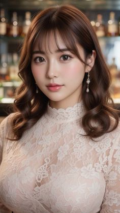 Woman with long wavy hair wearing a lace top and earrings indoors