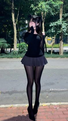 Woman with cat ears and black tights standing outdoors