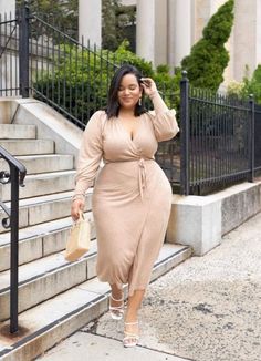 Woman in a beige wrap midi dress walking down outdoor stairs