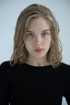 Woman with blonde hair and blue eyes wearing a black shirt