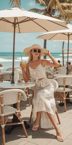 Woman in a straw hat and sunglasses at an outdoor beach cafe