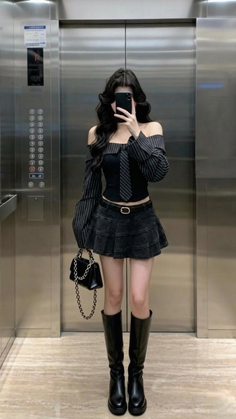 Woman in an off-shoulder top and mini skirt taking a mirror selfie in an elevator
