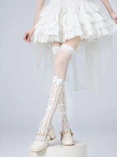 Person in a white ruffled dress and patterned thigh-high socks with bows