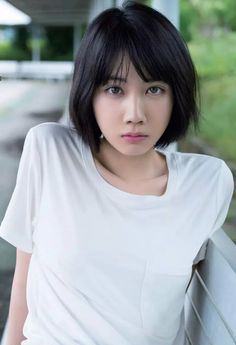 Woman with short black hair wearing a white t-shirt outdoors