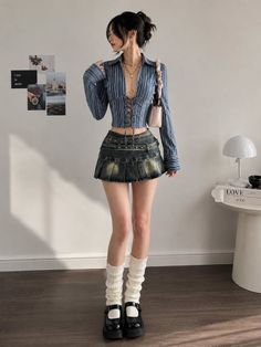 Woman in a striped top and denim skirt with leg warmers and mary jane shoes