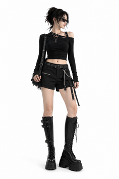 Woman in a black gothic outfit with platform boots and sunglasses
