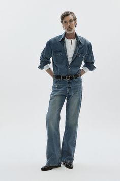 Man in a denim shirt and jeans with a white undershirt and black belt