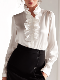 Woman in a white ruffled blouse and black skirt with hands in pockets