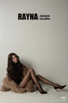 Woman with long wavy hair in black tights and high heels on a fur coat
