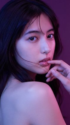 Woman with long dark hair and exposed shoulder in a provocative pose