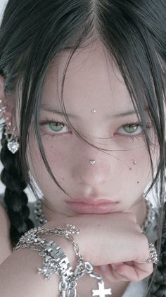 Close up portrait of a person with black hair, green eyes, and facial piercings