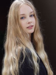 Young woman with long blonde hair and blue eyes looking at the camera