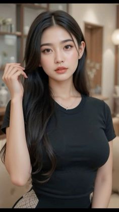 Woman with long black hair wearing a black t-shirt and necklace