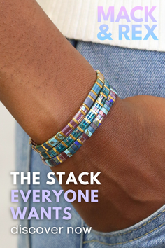 Close up of an arm wearing colorful beaded bracelets with denim in the background