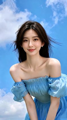 Woman in a blue off-shoulder dress against a bright blue sky