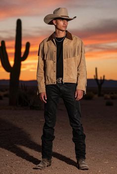 Man in a cowboy hat and fringe jacket in a desert at sunset