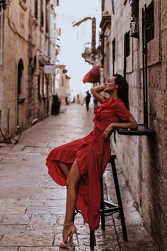 Woman in a red polka dot dress and high heels on a narrow street