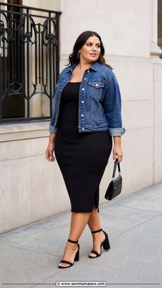 Woman in a black dress and denim jacket walking on a street