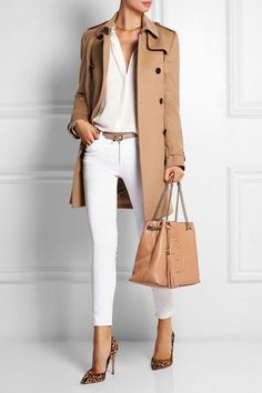 Woman in a tan trench coat, white jeans, and leopard print heels holding a handbag