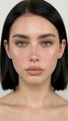 Close up portrait of a woman with short black hair and green eyes