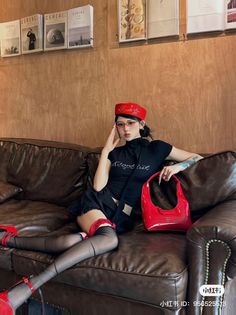 Woman in a red beret and black outfit with red accessories on a leather couch