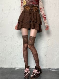 Person wearing a brown lace skirt, thigh-high stockings, and sneakers