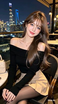 Woman with long hair in an off-shoulder top and mini skirt at a night city restaurant
