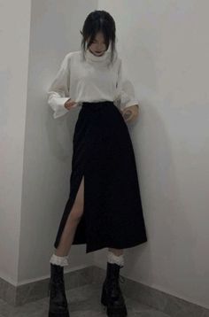Woman in a white turtleneck and black high-slit skirt with platform boots