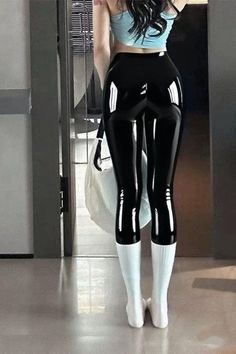 Woman in shiny black leggings and a crop top from behind