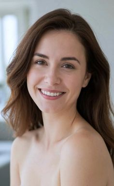 Woman with long brown hair smiling, with exposed shoulders and chest